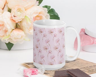 May include: White ceramic mug with a pink background and a repeating pattern of delicate pink and gold flowers. The mug has a large handle.