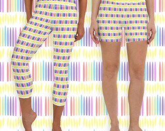 May include: White leggings and shorts with a repeating pattern of colorful vertical lines. The lines are in shades of red, orange, yellow, green, blue, and purple. The leggings are cropped at the calf, and the shorts are mid-thigh length.