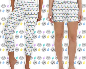 May include: White leggings and shorts with a repeating pattern of dog faces, dreidels, and colorful dots. The leggings are cropped at the calf. The shorts are high-waisted. The background is white.