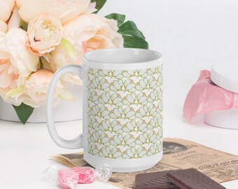 May include: White ceramic mug with a repeating pattern of light blue cotton blossoms with green stems on a white background.