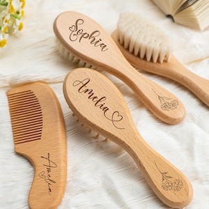 May include: A collection of wooden baby hairbrushes and a comb. The brushes are engraved with the names "Sophia" and "Amelia", and the comb is engraved with "Amelia". The brushes have soft bristles, and the comb has fine teeth. Floral designs are also engraved.