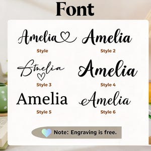 Może przedstawiać: Tabela wyboru czcionek przedstawiająca imię Amelia w sześciu r&oacute;żnych czarnych stylach typograficznych. Każdy styl jest oznaczony od Style 1 do Style 6. Tabela zawiera nagł&oacute;wek Font oraz notatkę na dole: Note: Engraving is free.