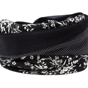 Puede incluir: Un calentador de cuello con estampado en blanco y negro. El calentador de cuello presenta una banda negra lisa, un estampado de lunares y un diseño floral. El accesorio está hecho de tela suave y está diseñado para mantener el cuello caliente.