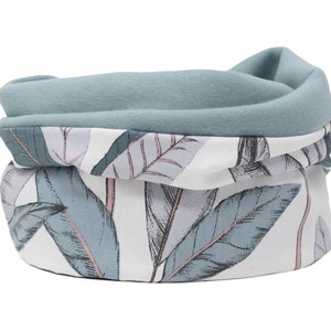 Op de afbeelding: Een zachte, blauw-witte nekwarmer met een bladmotief. De nekwarmer is gemaakt van een zachte, comfortabele stof en is perfect om warm te blijven in de winter.