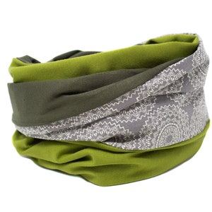 May include: A green and gray fabric neck warmer with a white mandala pattern. The neck warmer is folded and rolled up.