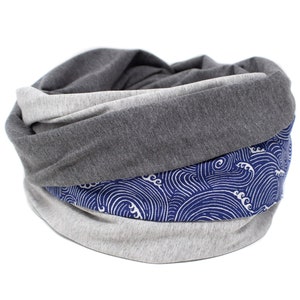 May include: A gray and white infinity scarf with a blue and white wave pattern. The scarf is made of a soft, comfortable fabric and is perfect for keeping warm in the winter.