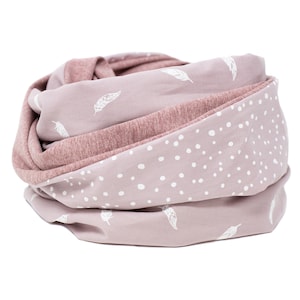 May include: A soft pink infinity scarf with a white feather pattern on one side and a white polka dot pattern on the other side.