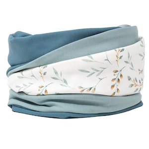 Könnte beinhalten: Ein blauer und weißer gemusterter Halsschmeichler mit Blumenmuster. Der Halsschmeichler ist aus weichem Stoff gefertigt und perfekt, um sich im Winter warm zu halten.