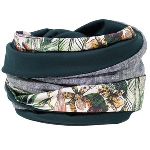 Puede incluir: Un calentador de cuello reversible verde y gris con un estampado floral con orquídeas y hojas.