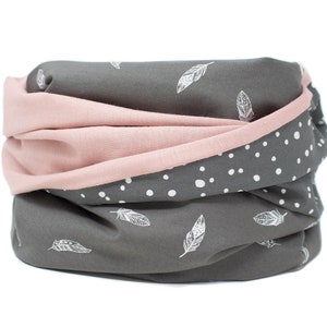Peut inclure: Un tour de cou réversible gris et rose avec un motif de plumes blanches d'un côté et des pois blancs de l'autre.