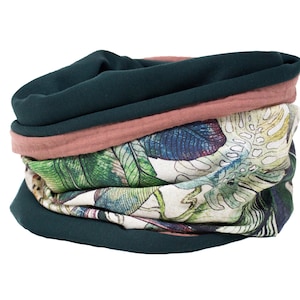 Puede incluir: Un calentador de cuello de tela verde y rosa con estampado floral de hojas y flores.