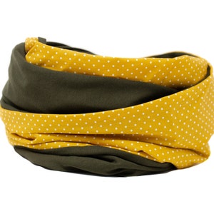 Könnte beinhalten: Ein gelber und grüner Stoff-Halswärmer mit weißen Punkten. Der Halswärmer ist gefaltet und zu einem Kreis gerollt.