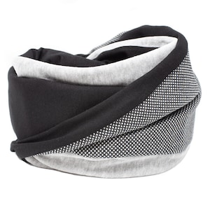 Puede incluir: Una bufanda infinita negra y gris con un patrón texturizado. La bufanda está hecha de una tela suave y cómoda.