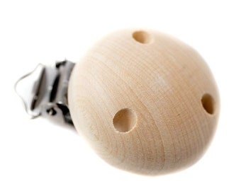 May include: A wooden pacifier clip with a natural finish. The clip has a round wooden bead with three evenly spaced holes. A metal clip is attached to the wooden bead.