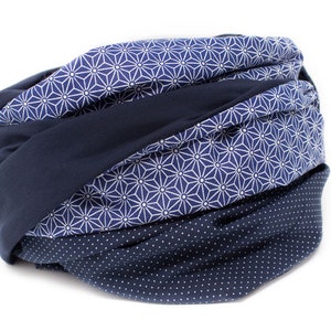 May include: A navy blue scarf with a white geometric pattern and a navy blue polka dot pattern.