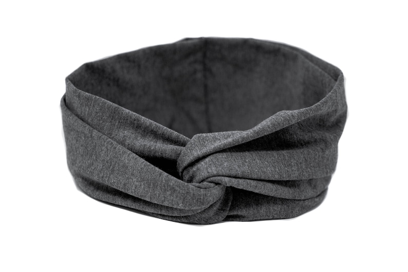 May include: A gray fabric headband with a knotted design. The headband is made of a soft, stretchy material.