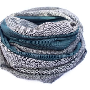 May include: A gray and teal infinity scarf with a herringbone pattern.