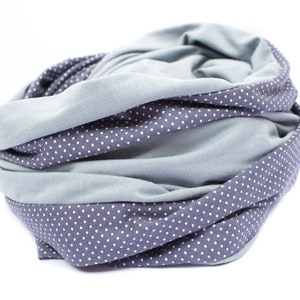May include: A gray and blue infinity scarf with a white polka dot pattern. The scarf is made of a soft, stretchy fabric and is perfect for keeping warm in the winter.