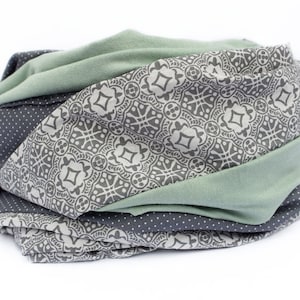 May include: A green, gray, and white patterned fabric headband. The headband is made of soft, stretchy fabric and is perfect for keeping your hair out of your face.