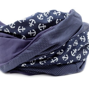 May include: A navy blue scarf with a white anchor pattern on one side and a navy blue polka dot pattern on the other side.