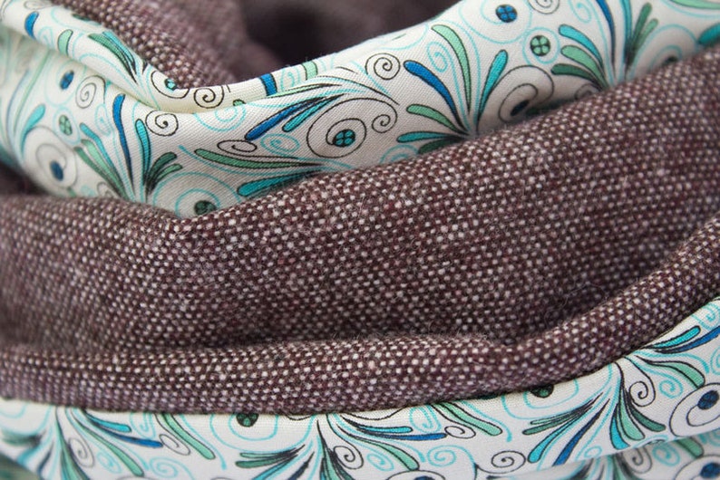 Peut inclure: Une &eacute;charpe en tissu marron avec un motif floral blanc et bleu. L'&eacute;charpe est pli&eacute;e en deux et le motif floral est visible des deux c&ocirc;t&eacute;s.