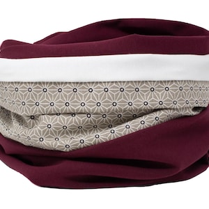 Puede incluir: Un cuello de cuello burdeos con una franja blanca y un patrón geométrico beige.