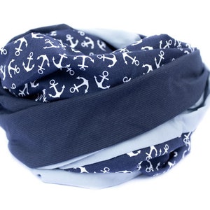 May include: A blue and light blue infinity scarf with a white anchor pattern.