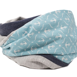 May include: A blue and gray infinity scarf with a white anchor and star pattern.