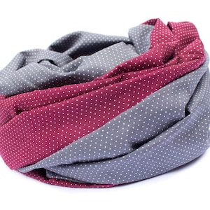 May include: A gray and burgundy infinity scarf with white polka dots. The scarf is made of a soft, comfortable fabric and is perfect for keeping warm in the winter.