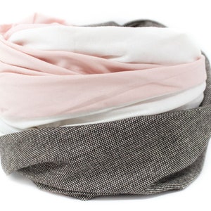 May include: A soft, multi-colored scarf with a pink, white, and brown striped pattern. The scarf is made of a soft, comfortable fabric and is perfect for keeping warm in the winter.