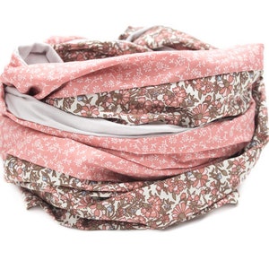May include: A pink and white floral patterned infinity scarf. The scarf is made of soft fabric and is perfect for adding a touch of style to any outfit.