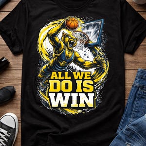 May include: Black t-shirt with a yellow and blue basketball-themed graphic. The design shows a player dunking a ball, with the text "ALL WE DO IS WIN". The shirt is made of a soft material.