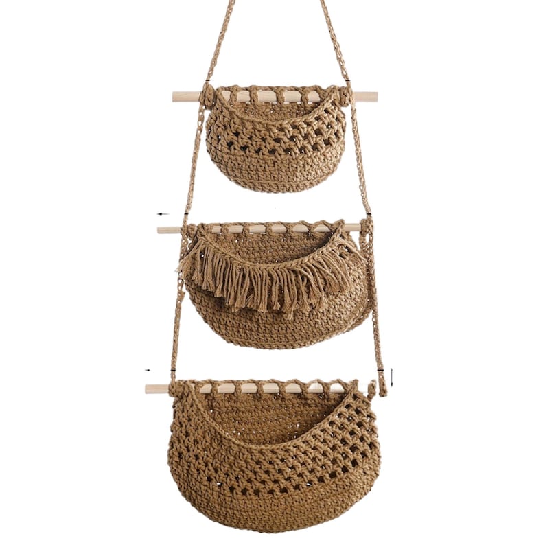 Puede incluir: Tres cestas colgantes de almacenamiento de fibra natural tejida. Cada cesta est&aacute; suspendida por una cuerda de yute de una clavija de madera. La cesta del medio presenta un detalle de flecos. Ideal para organizar objetos peque&ntilde;os.