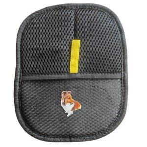May include: Black mesh car seat organiser with a yellow strap and a Sheltie dog graphic. The organiser has a pocket and is designed to attach to a car seat. The dog graphic is a detailed illustration of a Sheltie.