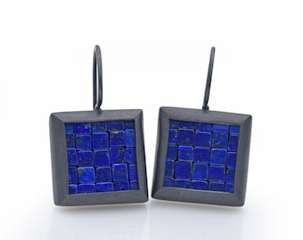 Può includere: Un paio di orecchini quadrati con cornice in metallo nero e design a mosaico di lapislazzuli blu.