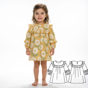 以下が含まれることがあります： 黄色いデイジーの花柄のドレスを着た幼い子供。ドレスは長袖で、フリル付きの襟が付いています。ドレスのパターンの線画が右下にあります。子供は白い背景の前に立っています。