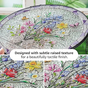 Puede incluir: Una ventana redonda de vidrieras con un dise&ntilde;o de ramo floral. El ramo presenta flores rosas, rojas, azules y amarillas con hojas verdes. La ventana tiene un acabado texturizado y un marco de metal negro.