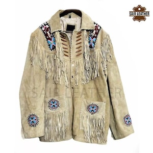 May include: A beige suede jacket with fringe detailing and beaded embellishments. The jacket has a button closure and two pockets. The jacket is decorated with a Native American inspired design.