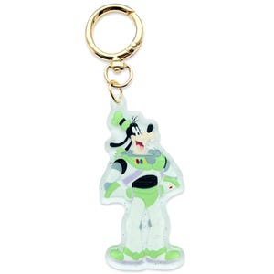 May include: A clear, glittery keychain featuring Goofy dressed as Buzz Lightyear. The keychain has a gold-colored clasp and a small ring. Goofy is wearing a green and white spacesuit with a purple stripe and black accents.