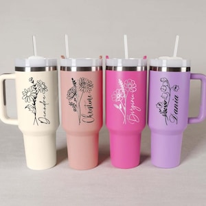 May include: Four insulated tumblers with handles and straws. The tumblers are in cream, pink, hot pink, and lavender. Each tumbler features a floral design and a name in script. The cream tumbler says "Deandre", the pink tumbler says "Christine", the hot pink tumbler says "Virgina", and the lavender tumbler says "Dania".