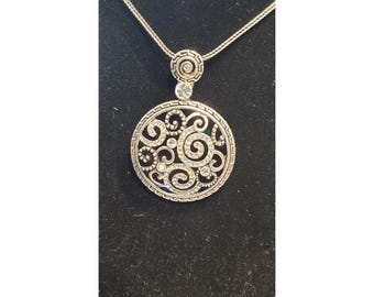 Collar con colgante redondo de plata con piedras preciosas y cierre de garra.