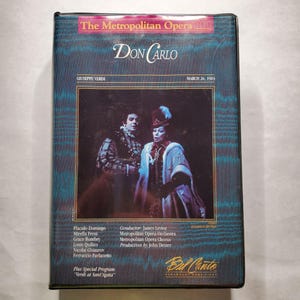 May include: A vintage VHS tape of "Don Carlo" by Giuseppe Verdi from The Metropolitan Opera. The cover features a photo of two costumed opera singers. The tape includes the date March 26, 1983, and the Bel Canto Paramount Home Video logo.