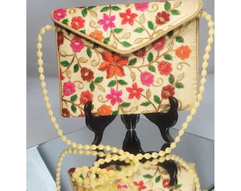 Bolsa feminina tipo carteira envelope, estilo transversal, com estampa floral e bordados.