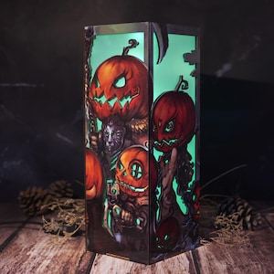 May include: A rectangular Halloween-themed lantern with a green interior. The lantern features illustrations of carved pumpkins with menacing expressions, a grim reaper, and other spooky characters. The artwork is in shades of orange, brown, and green.