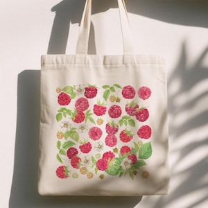 May include: A cream-colored tote bag featuring a vibrant watercolor design of ripe red raspberries, green leaves, and delicate white blossoms. The bag has two handles and is made of a sturdy fabric, perfect for carrying groceries or everyday items.