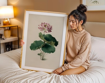 May include: A framed botanical print featuring a detailed illustration of a lotus flower with pink petals and large green leaves. The artwork is set against a neutral background and framed in a gold-colored frame.