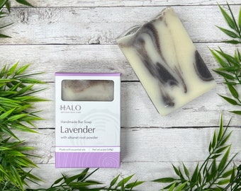 May include: A lavender-scented bar soap with alkanet root powder in a white box with purple accents. The soap is handmade and made with essential oils. The box has the text "HALO ARTISAN SKIN CARE Handmade Bar Soap Lavender with alkanet root powder Made with essential oils Net wt 4.5 oz (128g)"