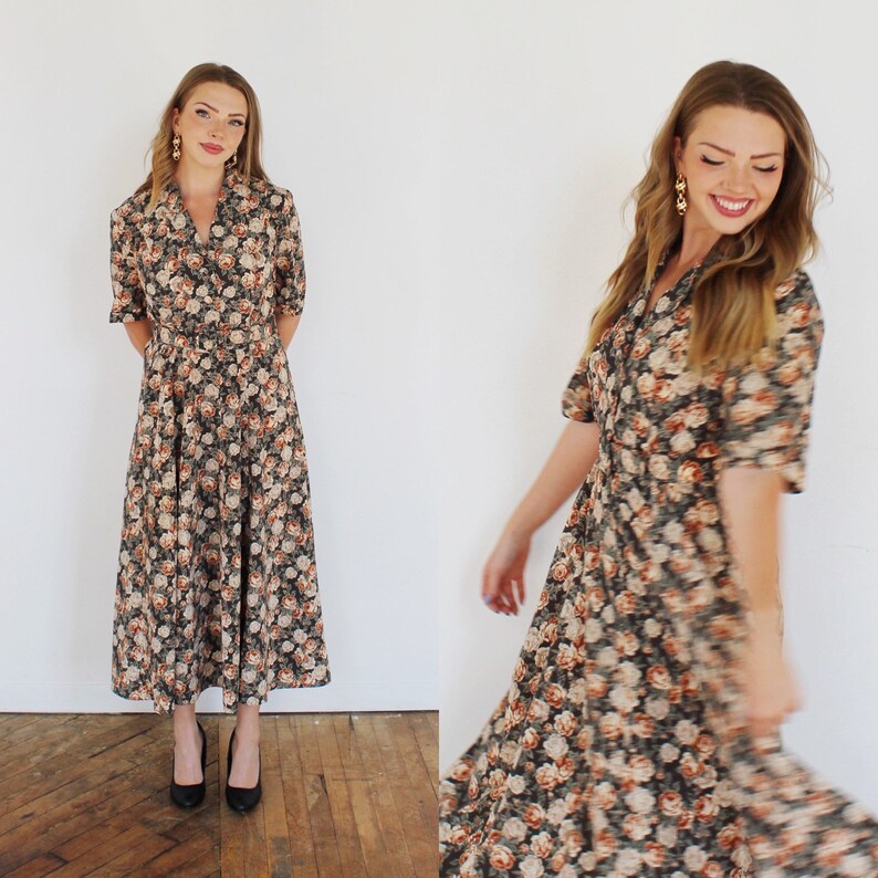 K&ouml;nnte beinhalten: Ein lang&auml;rmeliges Blumenkleid mit Knopfleiste und Kragen. Das Kleid hat einen dunklen Hintergrund mit einem Blumenmuster in Orange-, Braun- und Wei&szlig;t&ouml;nen.