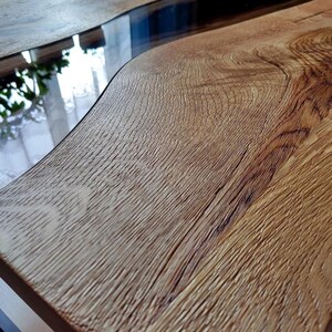 May include: A wooden coffee table with a natural wood finish and a clear epoxy resin river flowing through the center.