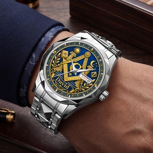 Könnte beinhalten: Eine silberfarbene Armbanduhr mit facettierter Lünette und Metallgliederarmband. Das blaue Zifferblatt zeigt goldfarbene freimaurerische Symbole, darunter Winkel und Zirkel, eine Sonne und einen Mond. Der Name David ist in Gold aufgedruckt.